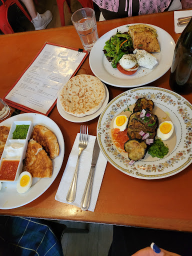 malawach on left, sabich plate bottom right, halloumi eggs top right