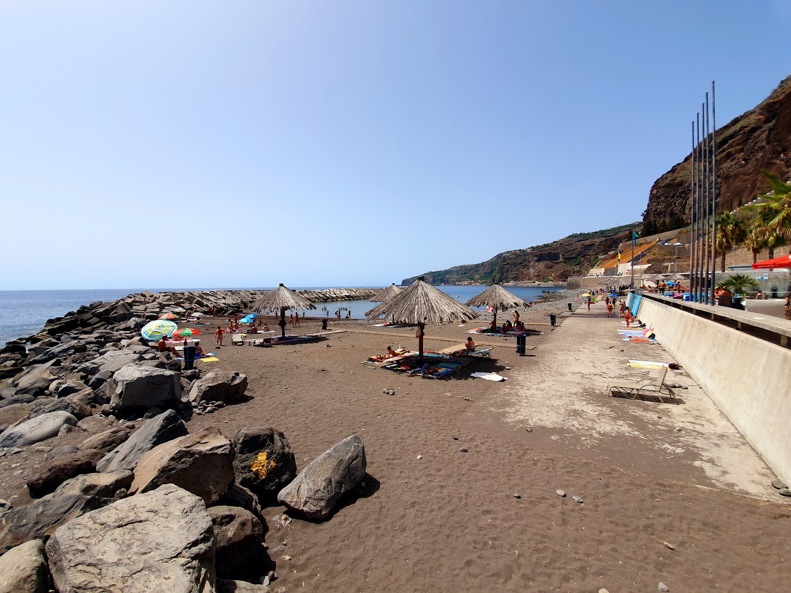 Foto de Praia Da Ribeira Brava com areia cinza e pedras superfície