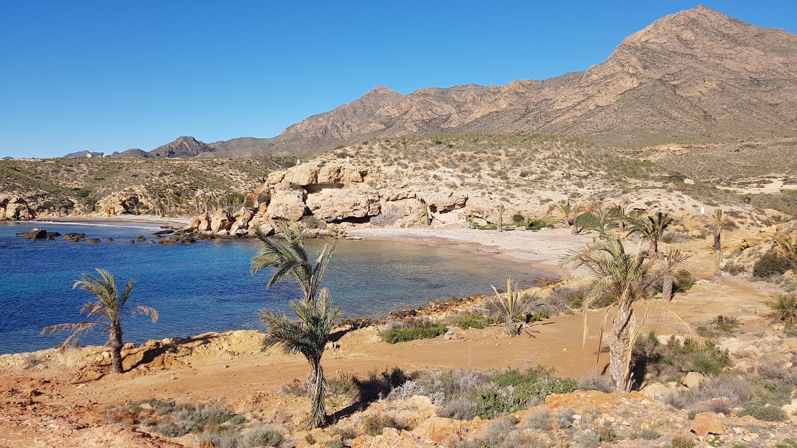 Foto di Playa de La Grua con una superficie del sabbia marrone