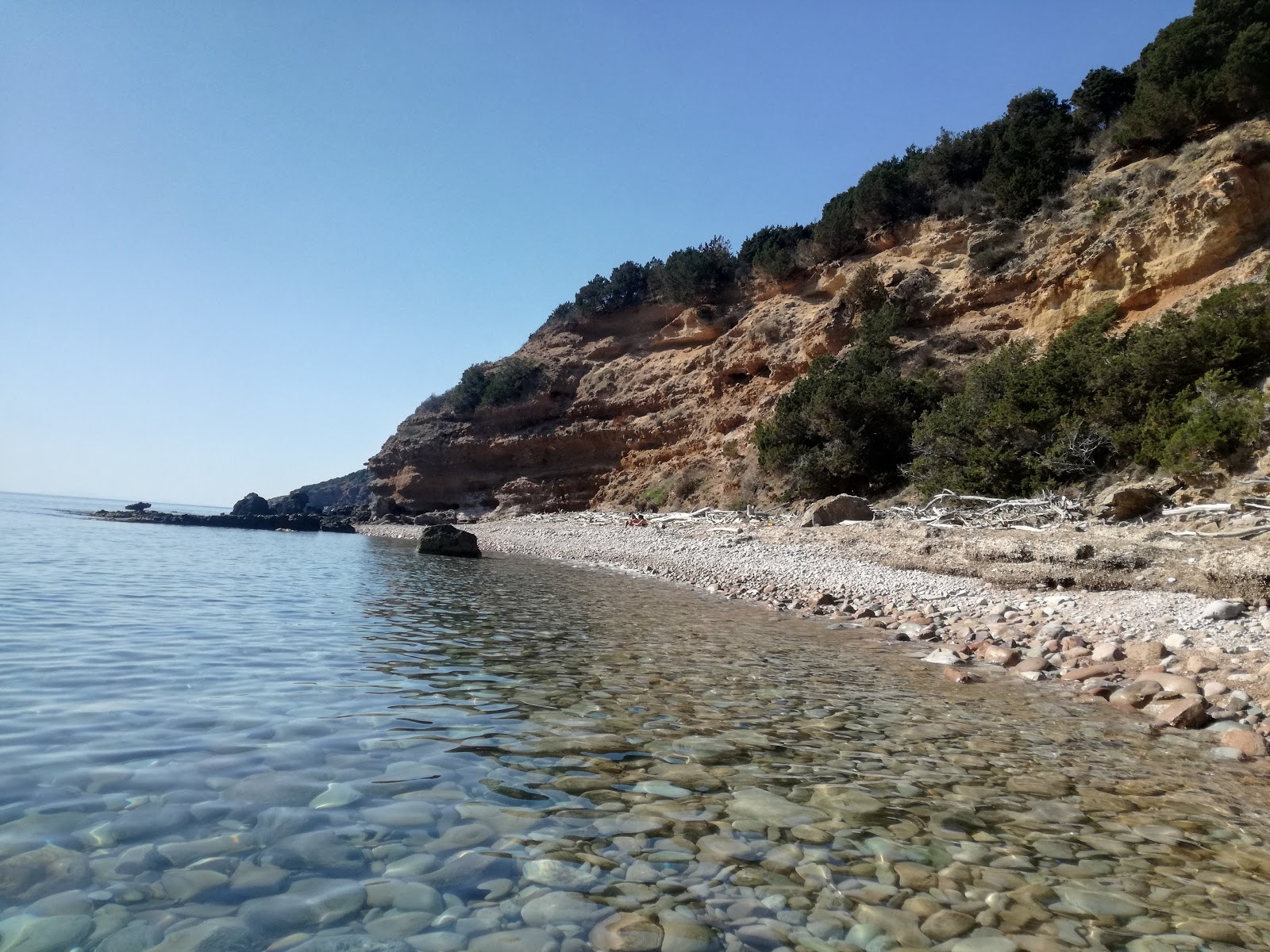 Cala Salto del Cervo'in fotoğrafı uçurumlarla desteklenmiş