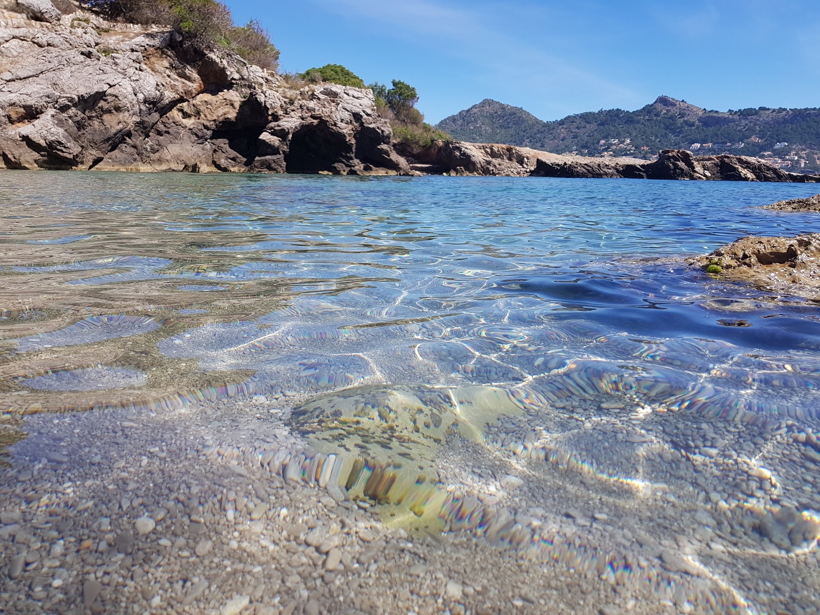 Foto av Cala Auberdans med blå rent vatten yta