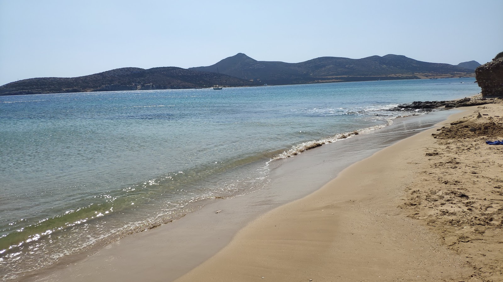 Foto von Agios Georgios beach und die siedlung