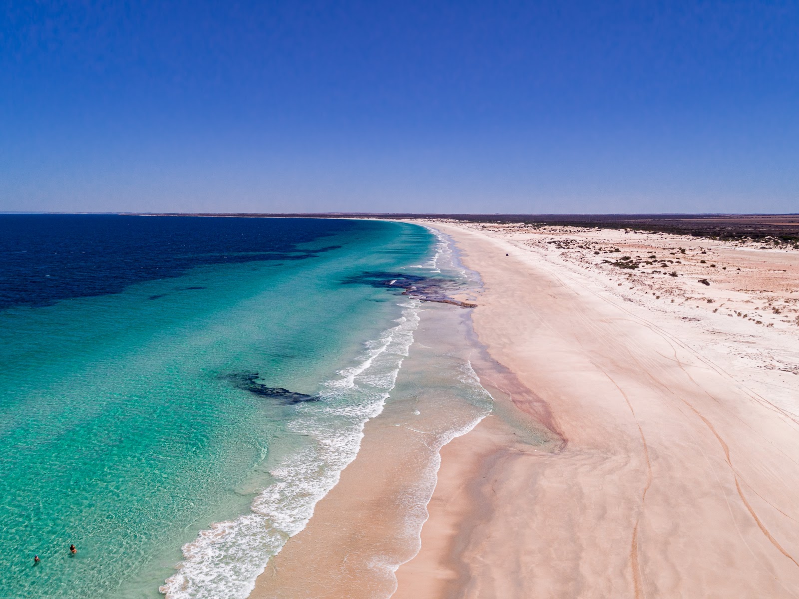 Fotografija Mills Beach z svetel pesek površino