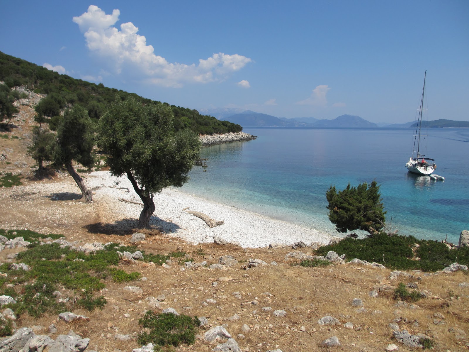 Foto von Ithaki wild beach IV mit beiger sand & kies Oberfläche