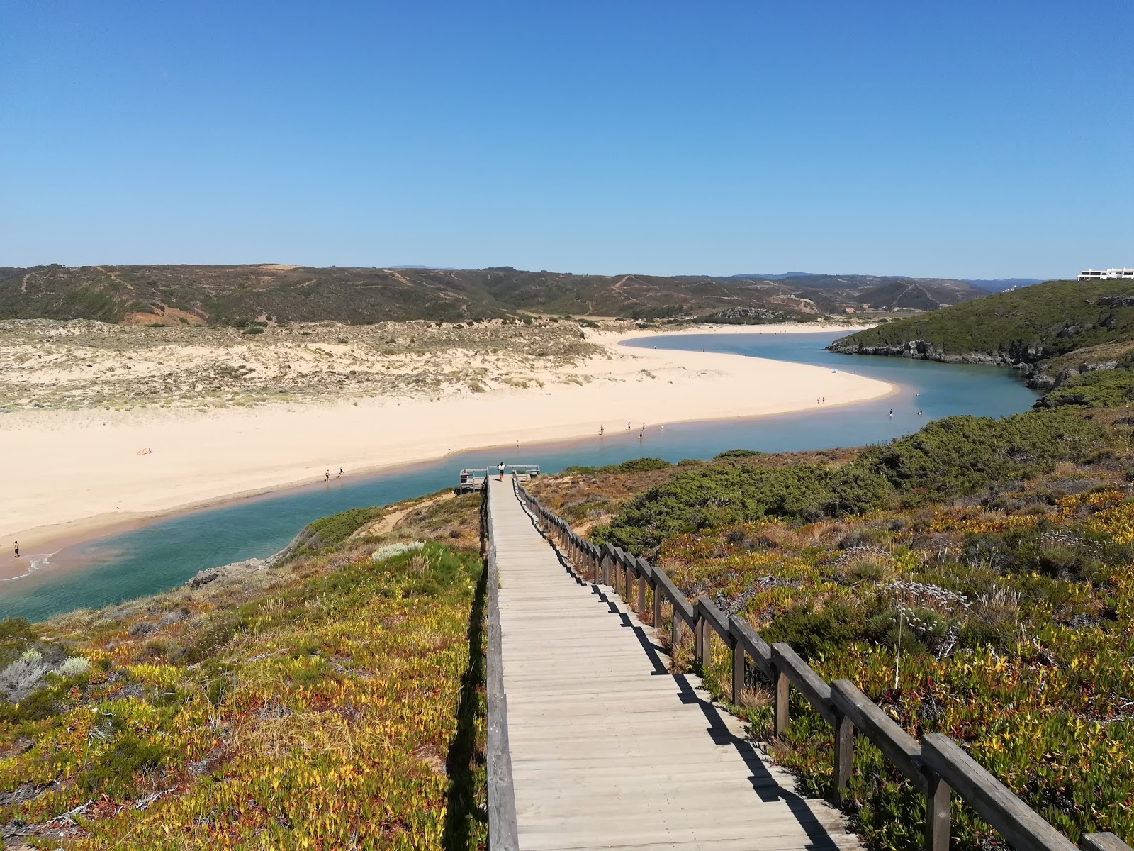 Foto di Praia da Amoreira circondato da montagne