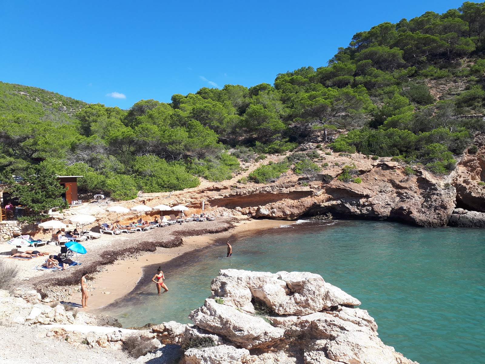 Photo of Cala Olivera with brown sand &  rocks surface