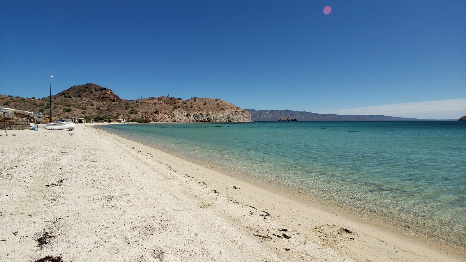 Fotografie cu Playa Los Cocos cu o suprafață de nisip de cochilii strălucitor