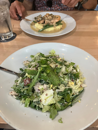Smoked chicken cobb salad, salmon dish in background