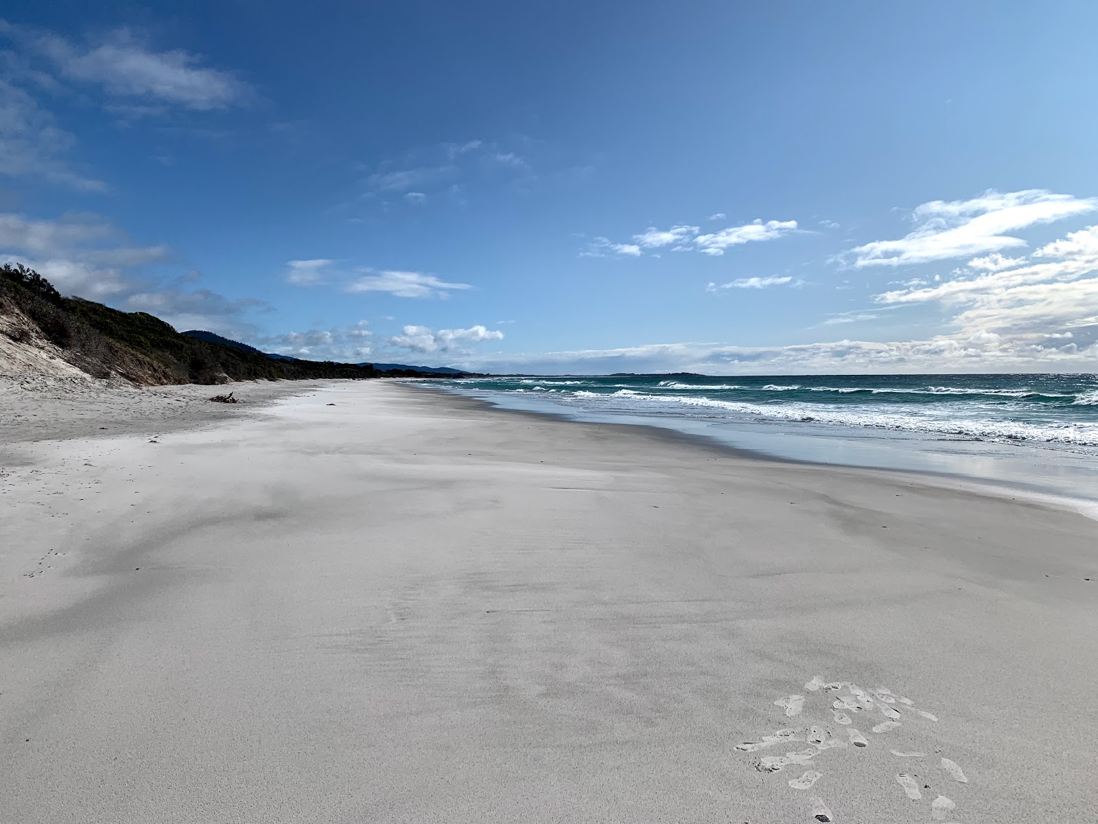 Foto av Denison Beach med vit sand yta