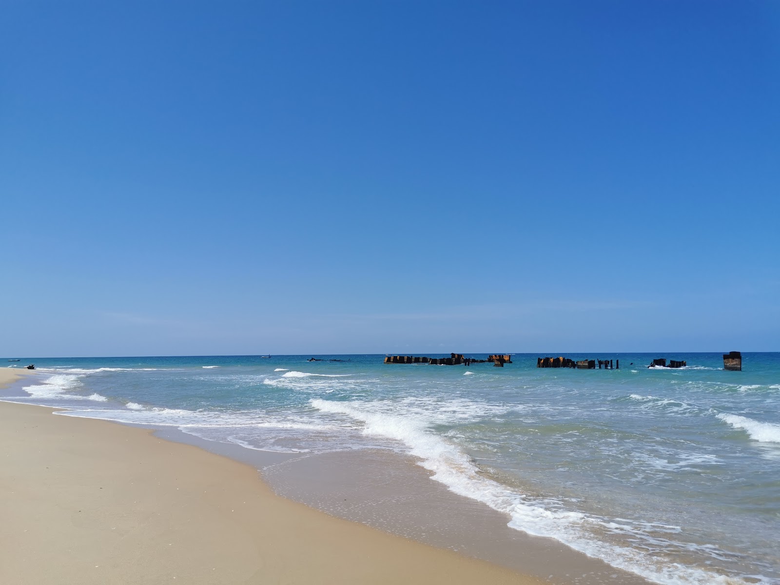 Foto di Karaiyamullivaikkal Beach con una superficie del sabbia beige