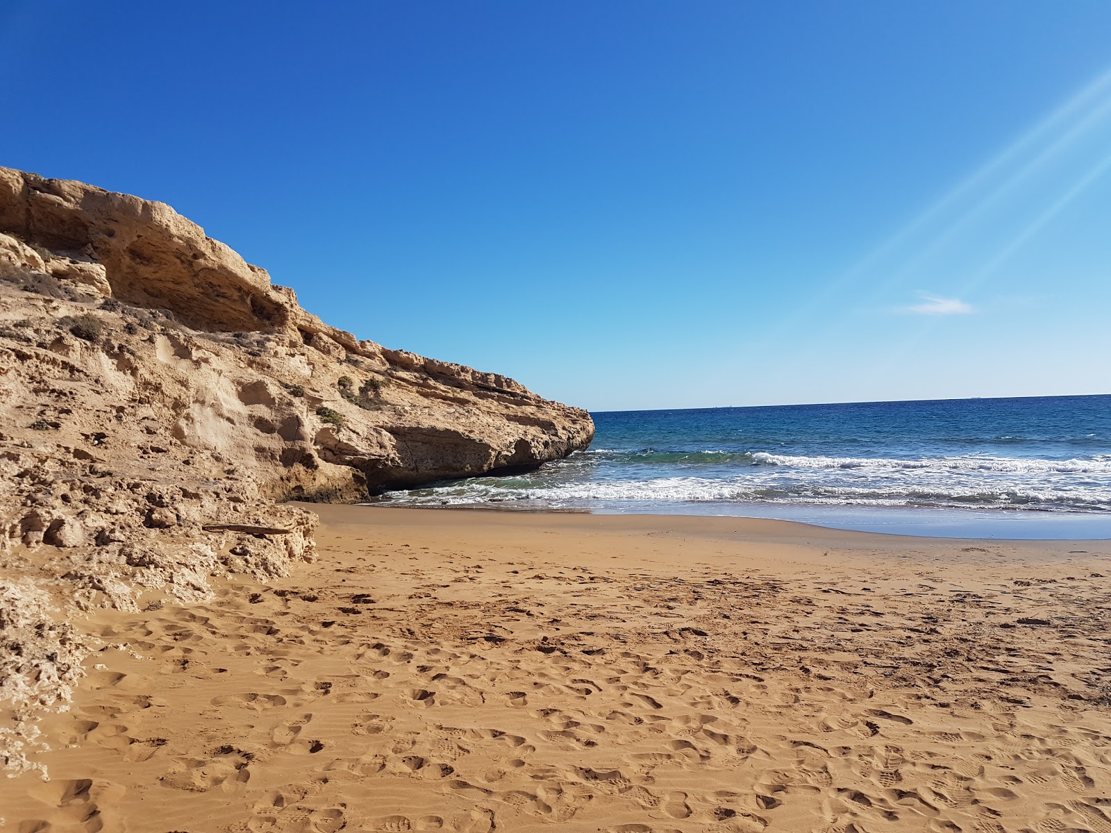 Valokuva Cala Doradaista. pinnalla ruskea hiekka:n kanssa
