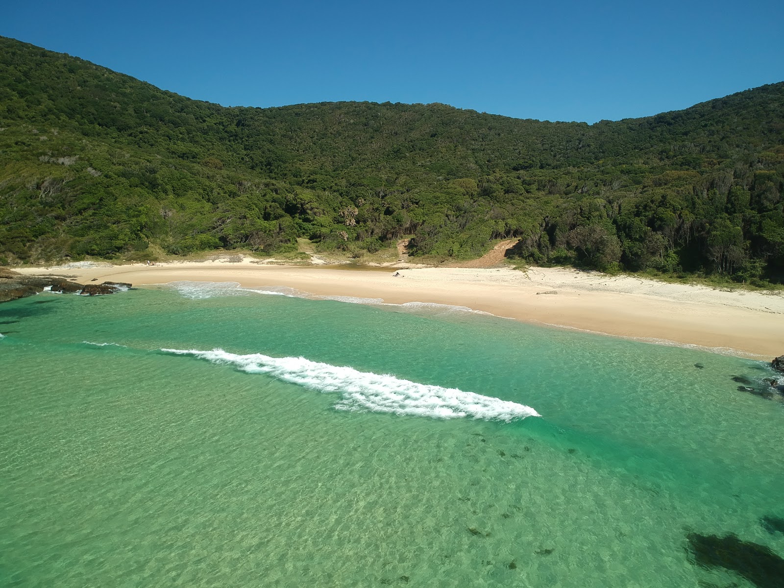 Fotografie cu McBrides Beach cu o suprafață de nisip beige fin