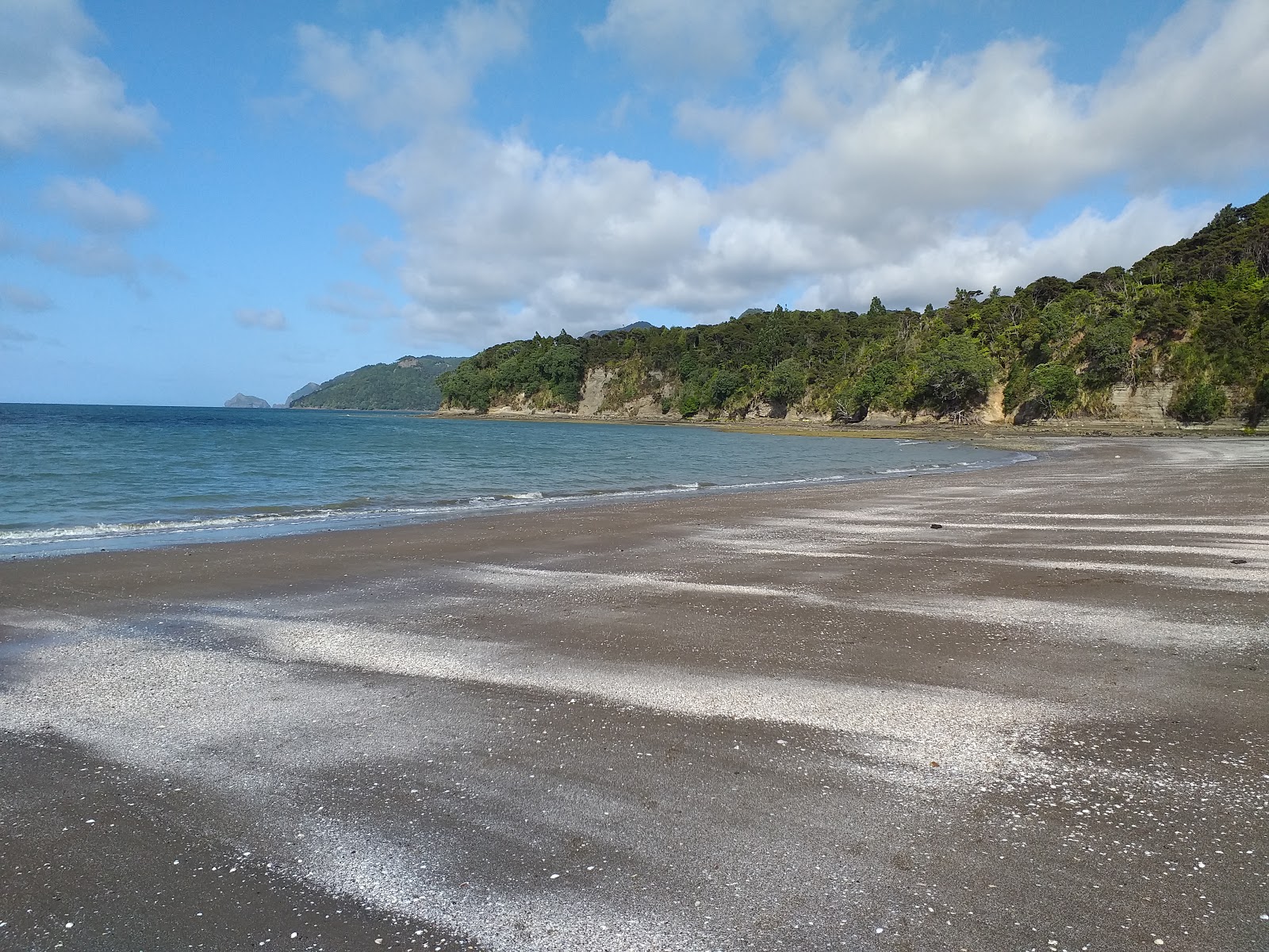 Valokuva Kaitarakihi Beachista. pinnalla harmaa hiekka:n kanssa