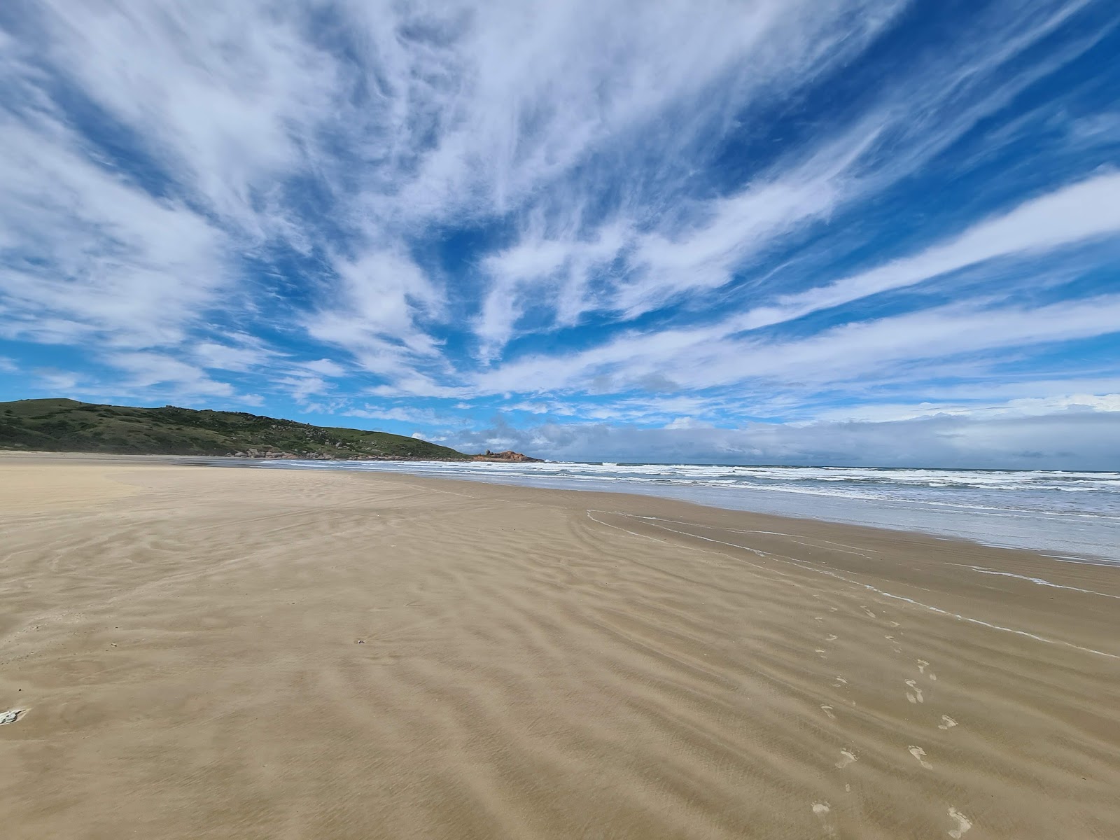 Foto di Praia da Gravata con una superficie del sabbia beige fine