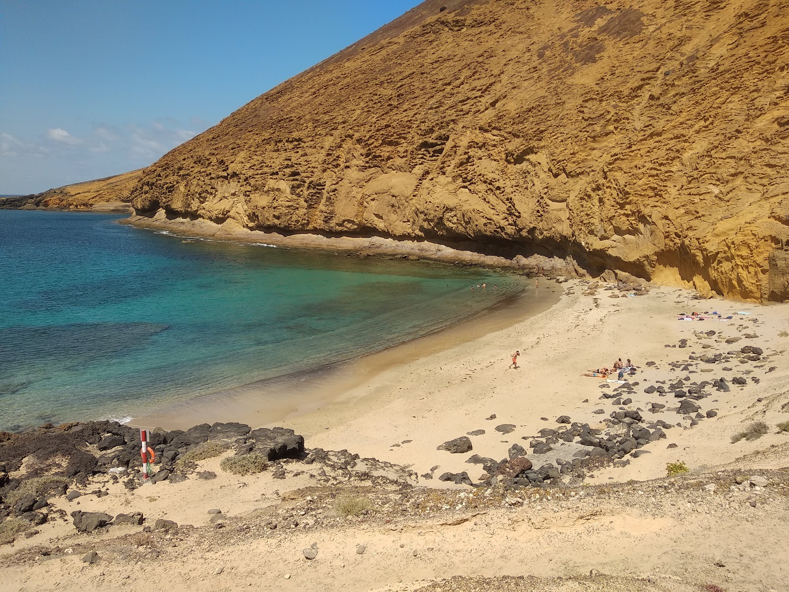 Foto av Playa Montana Amarilla med ljus sand och stenar yta