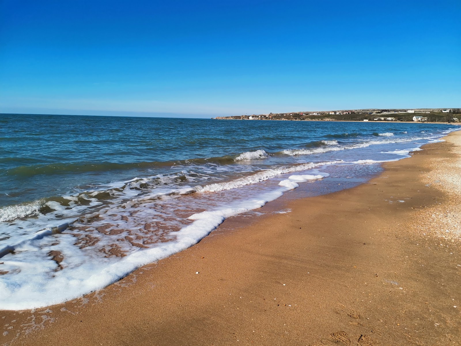 Fotografija Plyazh Zolotoye z svetel pesek površino