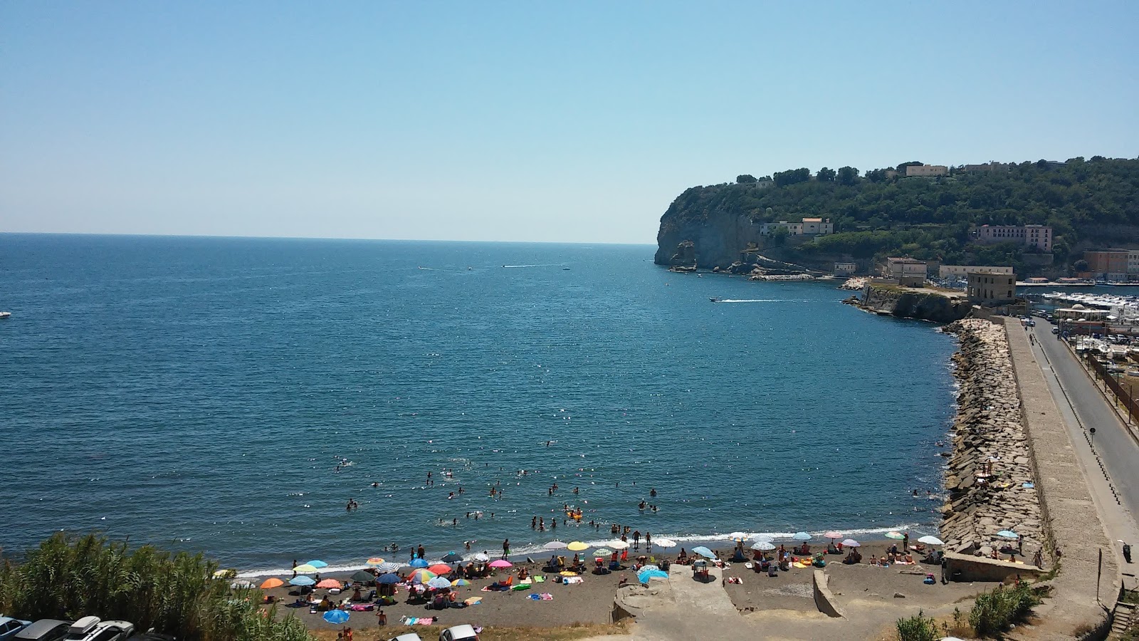 Foto av Spiaggia di via Nisida med musta hiekka ja kivi yta