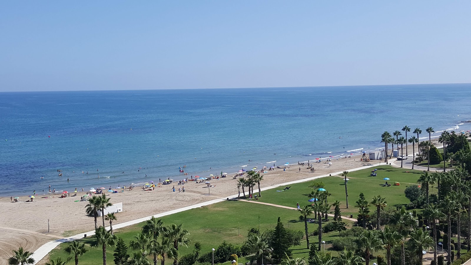 Zdjęcie Playa de les Amplaries z powierzchnią brązowy piasek