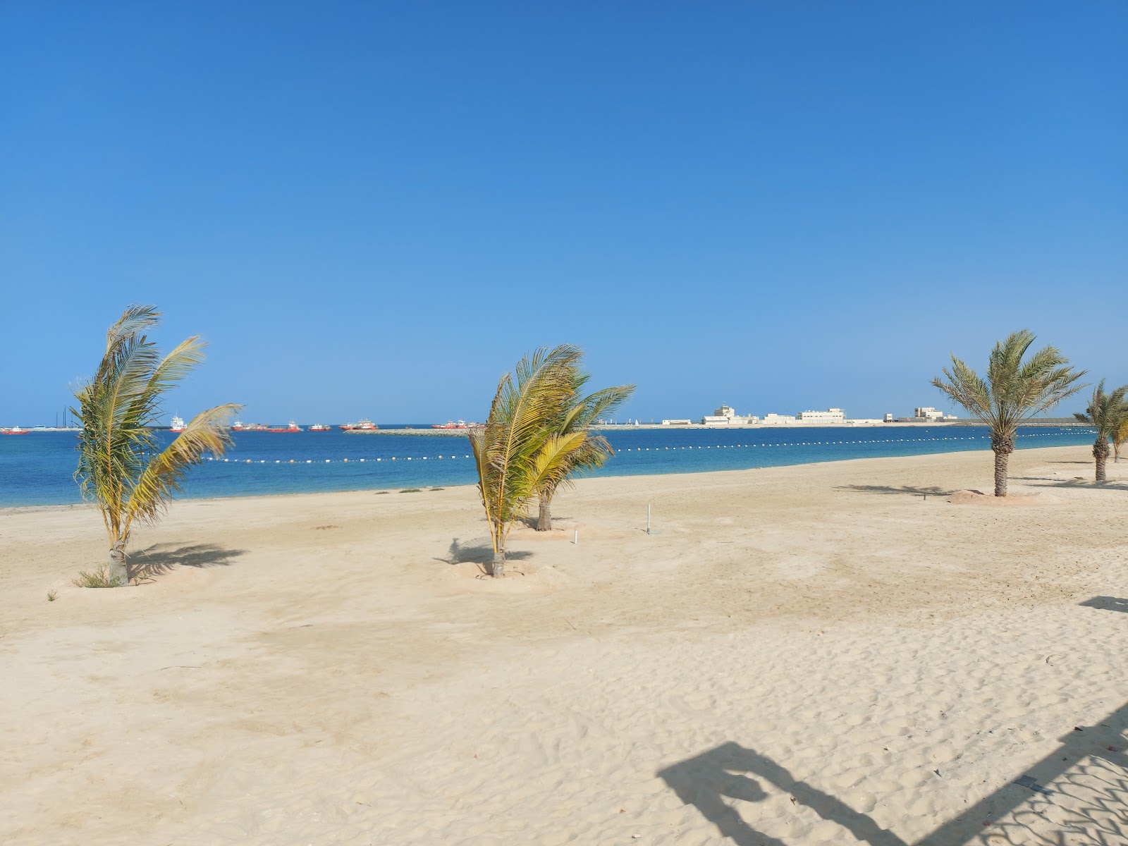 Foto de Al Mirfa Beach con arena beige superficie