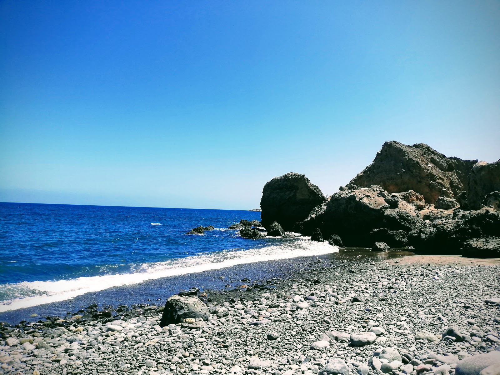 Valokuva Playa Lomo Galeonista. pinnalla harmaa hiekka ja kivi:n kanssa