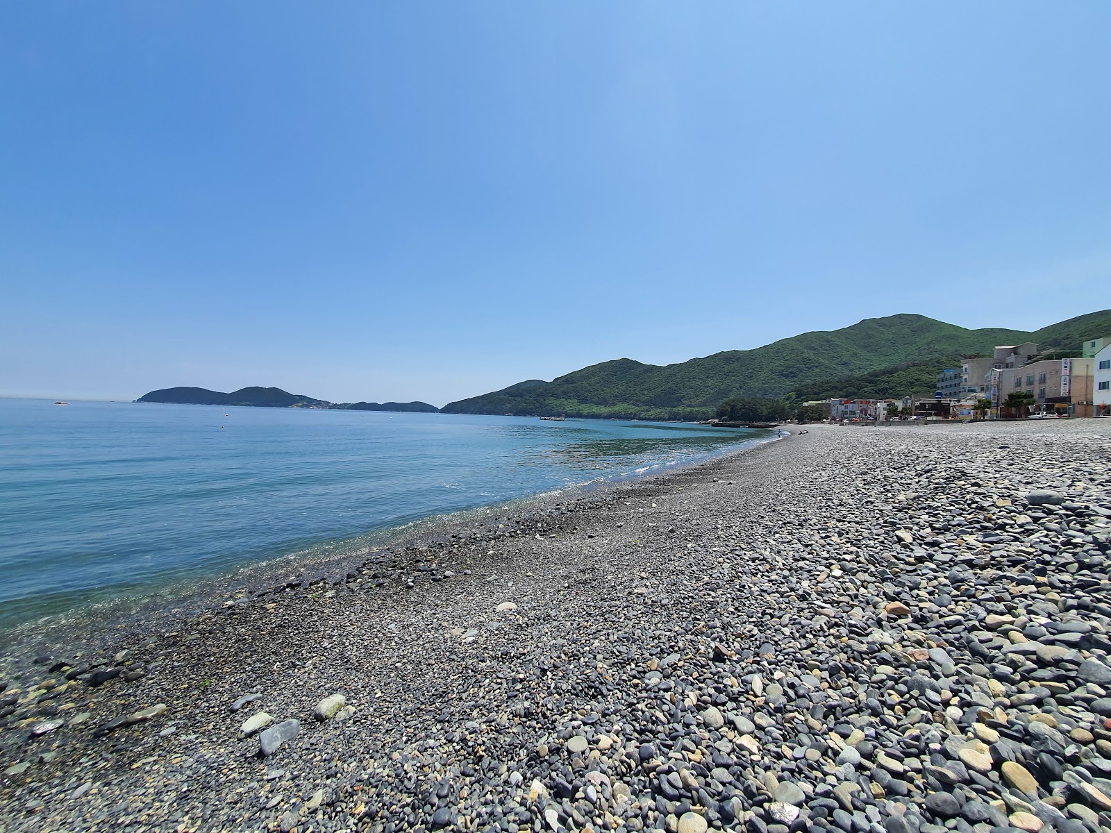 Hakdong Black Pearl Beach'in fotoğrafı turkuaz saf su yüzey ile