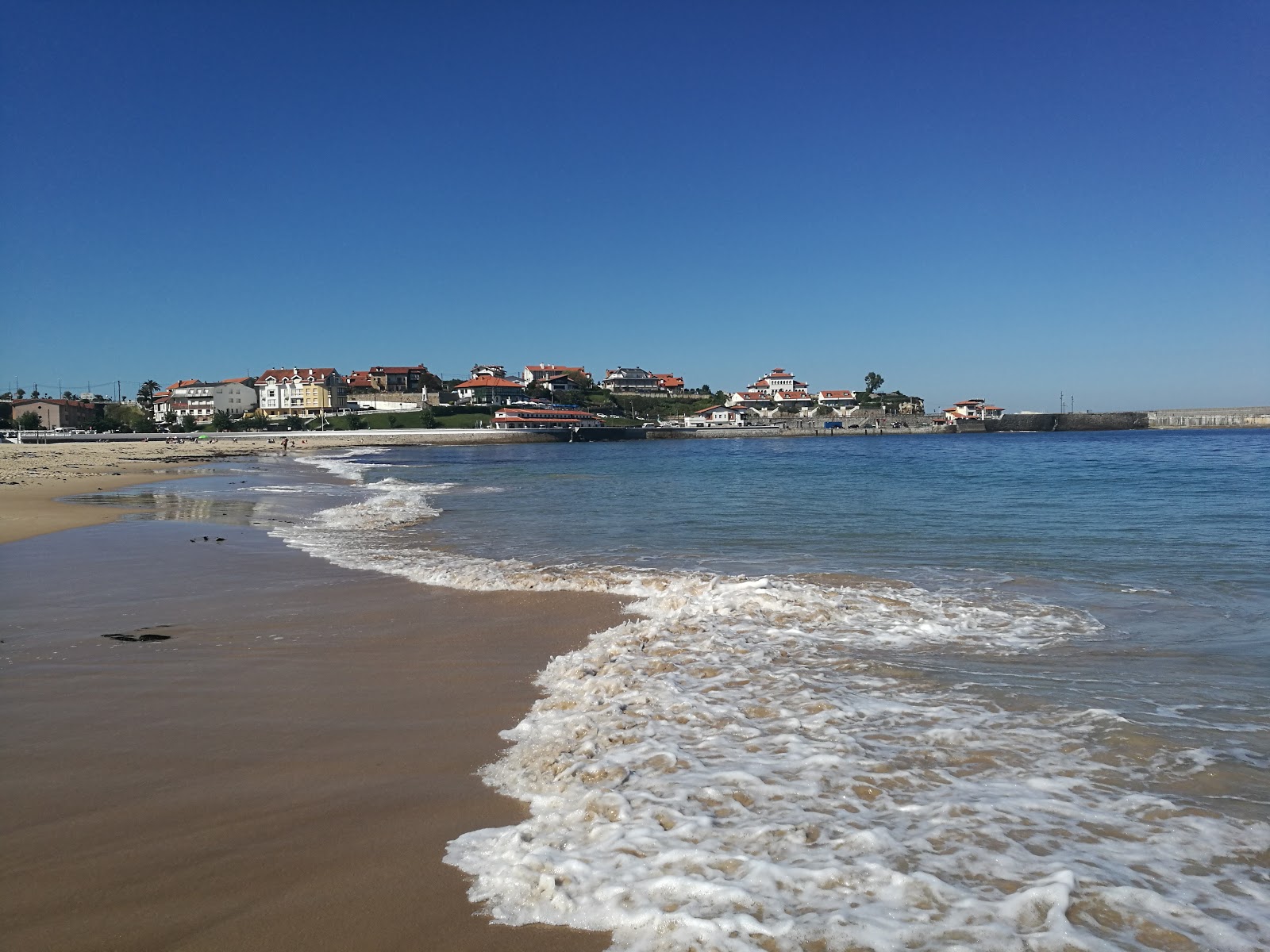 Foto av Comillas strand och bosättningen