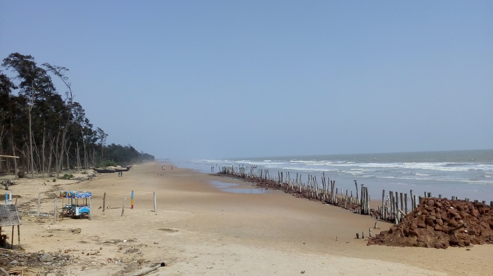 Valokuva Tajpur Sea Beachista. pinnalla turkoosi puhdas vesi:n kanssa