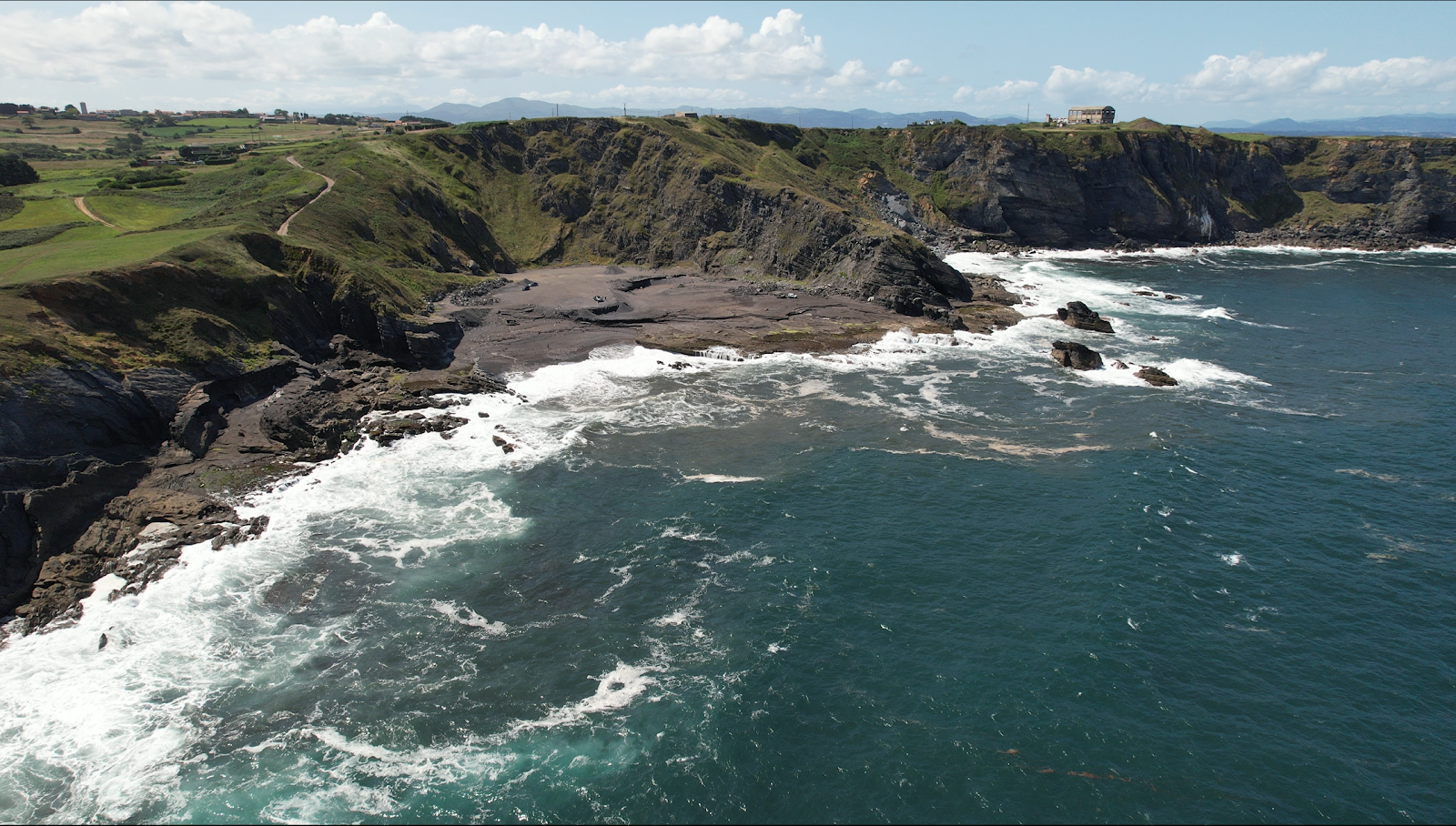 Photo de Playa de Portazuelos entouré de montagnes