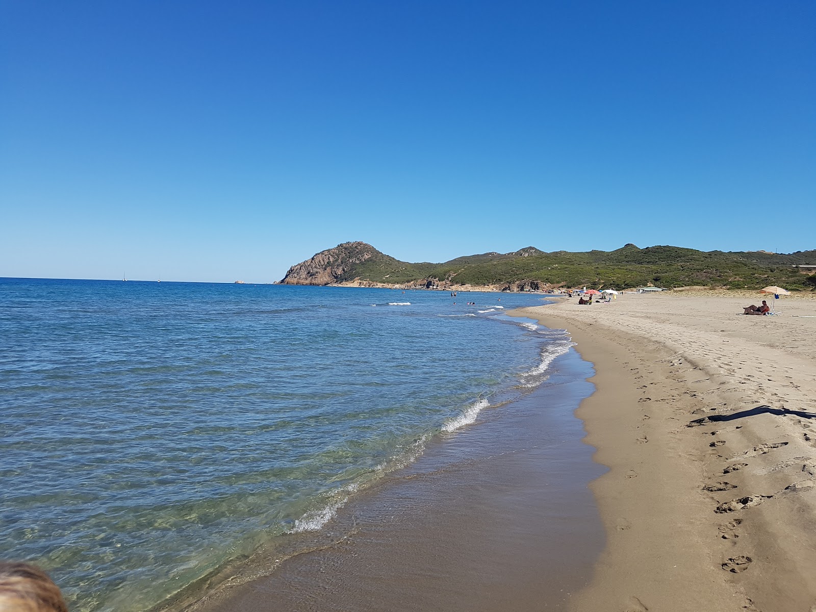 Foto von Spiaggia di Feraxi mit feiner grauer sand Oberfläche