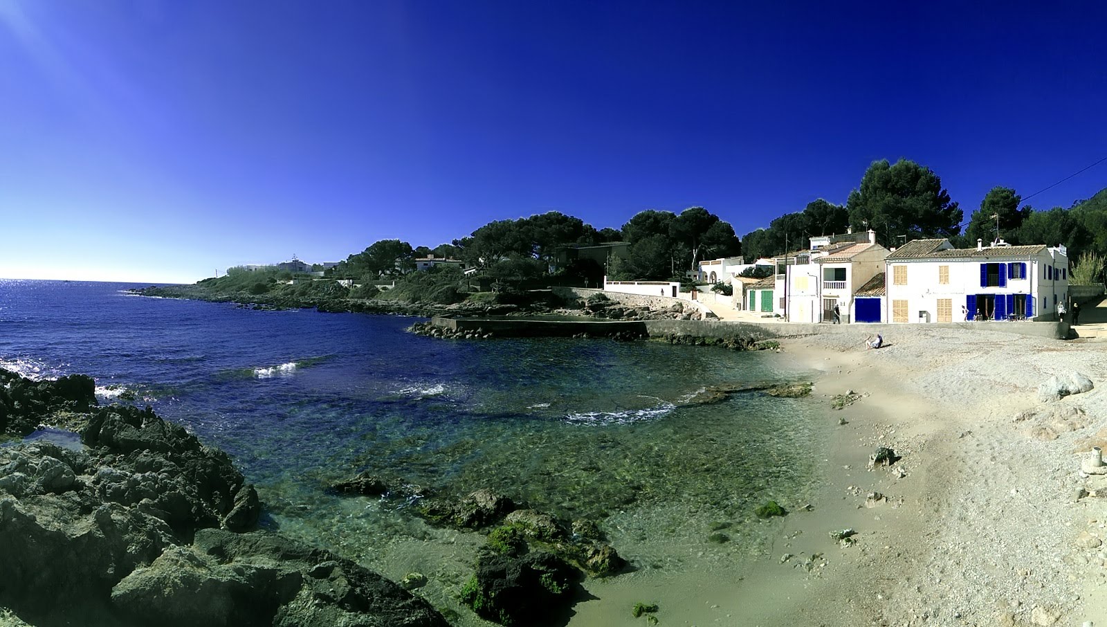 Photo of Cala Pedruscada with bright sand & rocks surface