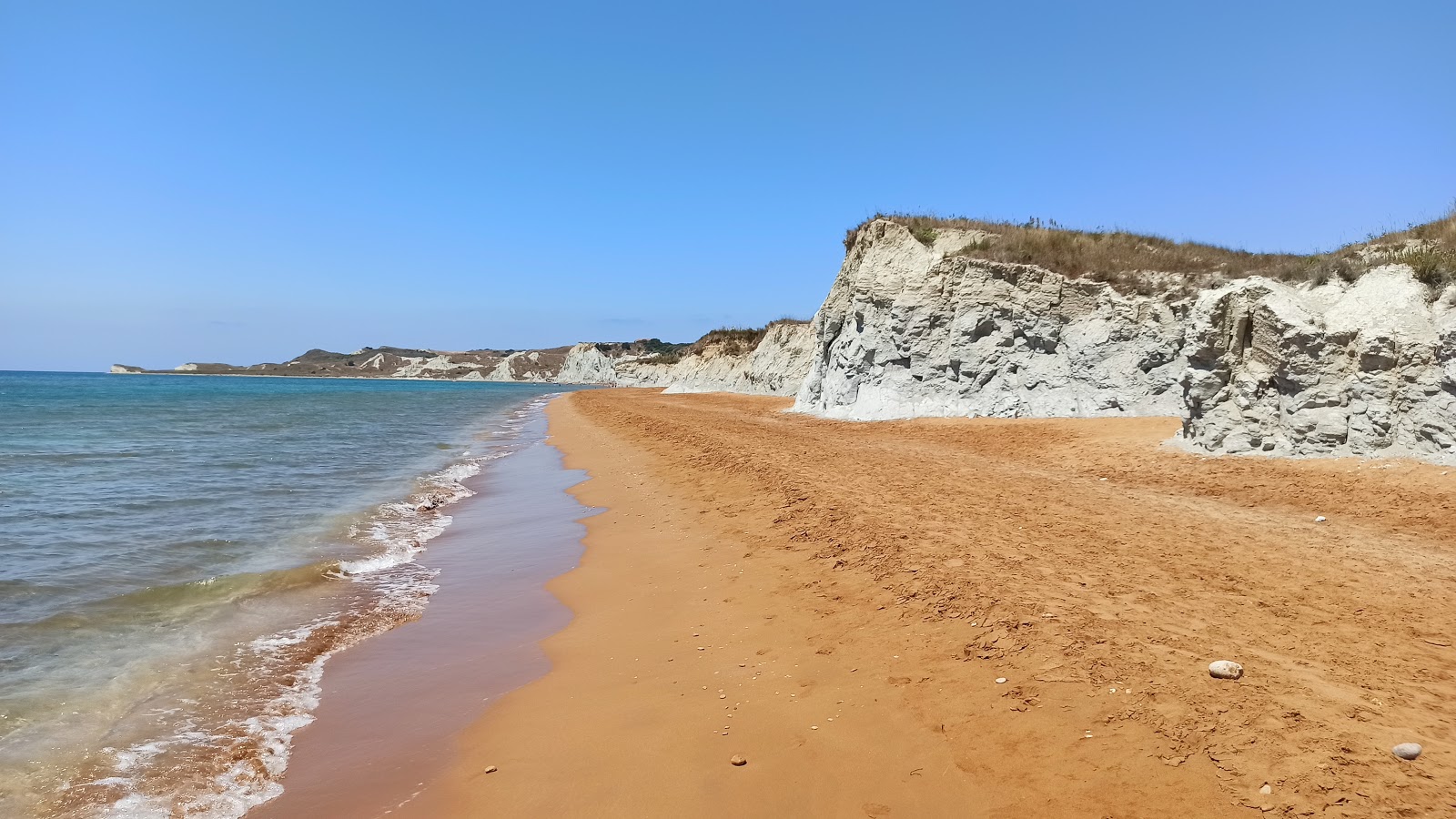 Foto van XI beach met fijn bruin zand oppervlakte