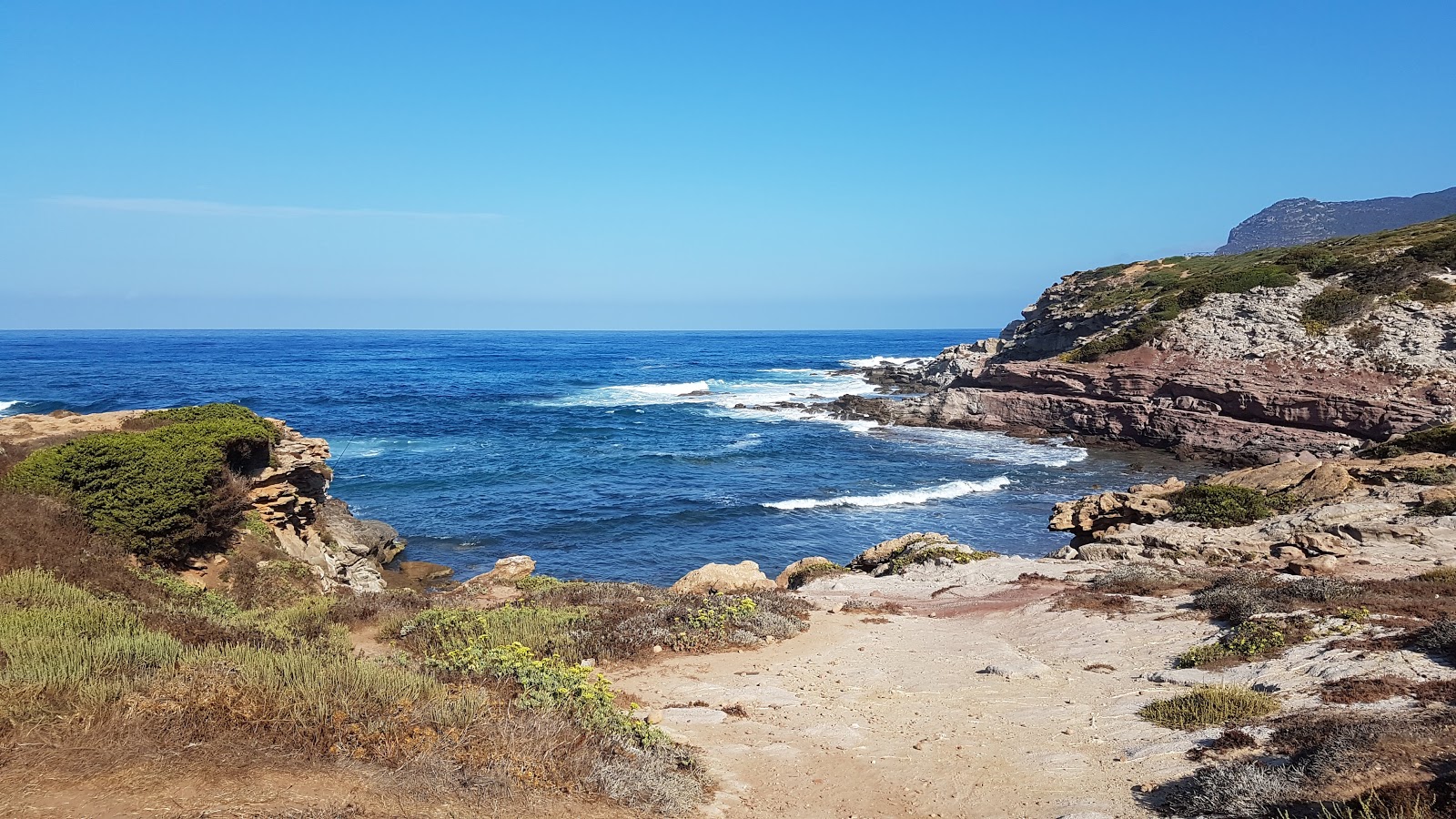 Foto av Cala Bantine Sale omgiven av klippor