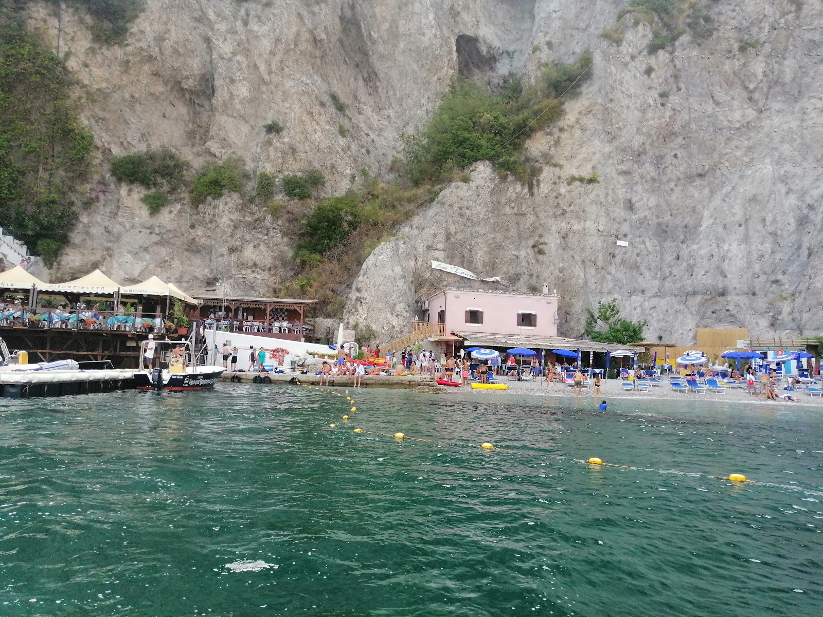 Valokuva Spiaggia di via Smeraldoista. ympäröity vuorilla