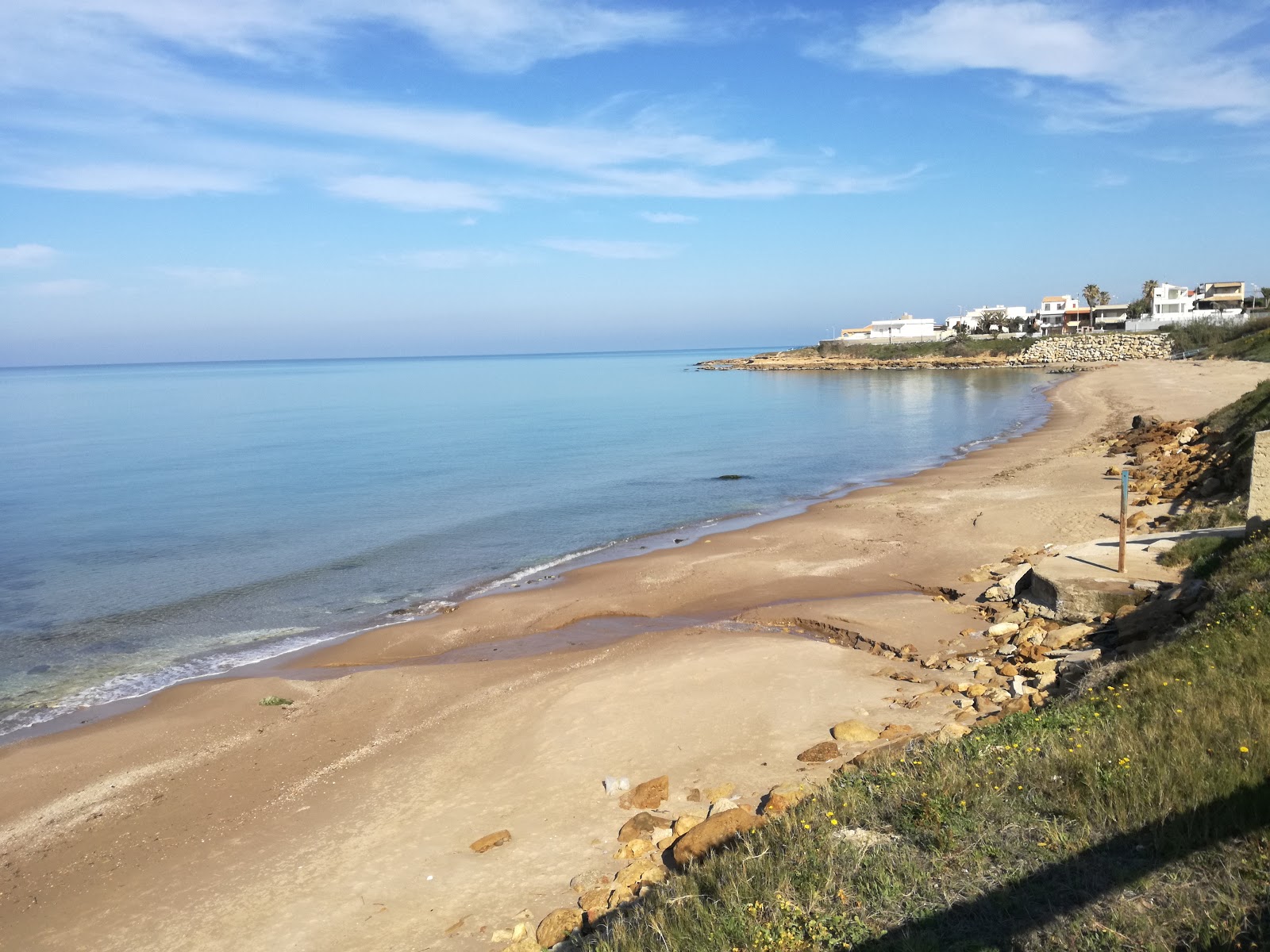 Foto di Baia Dorica con una superficie del sabbia marrone e rocce
