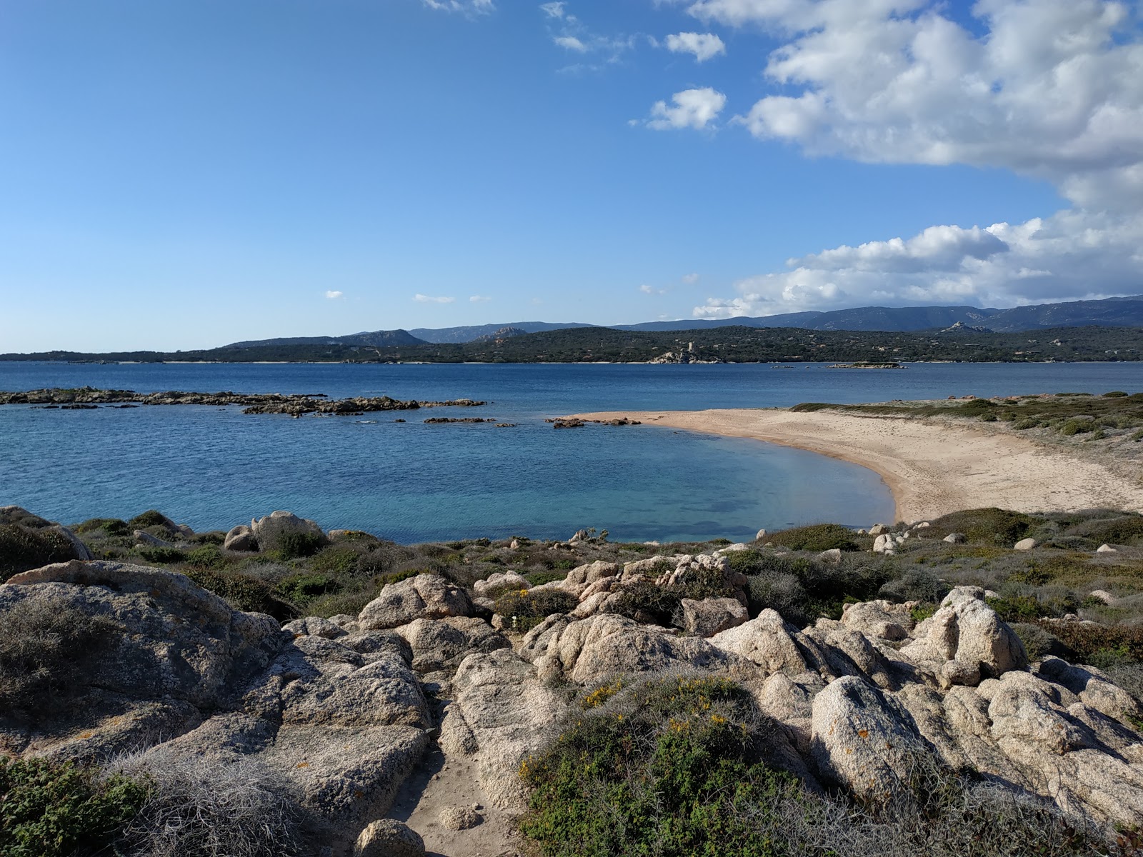Foto di La Testa beach X con una superficie del sabbia beige e rocce