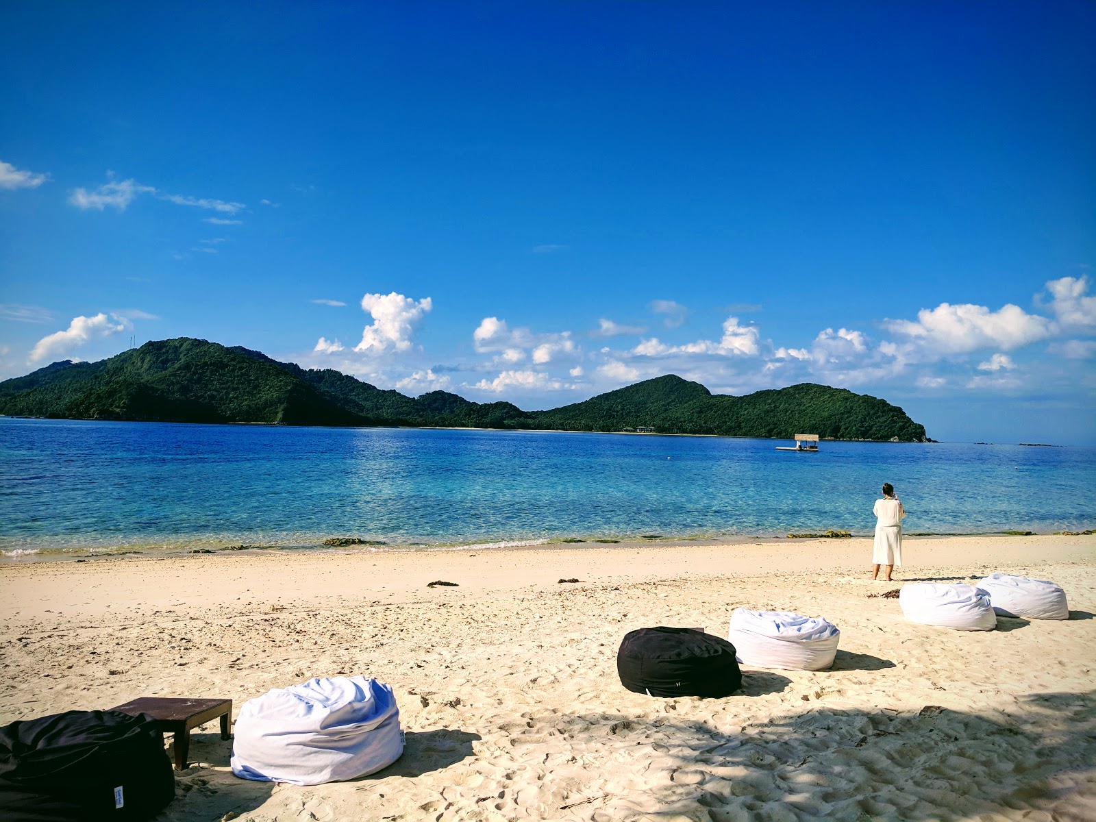 Foto von Pangulasian Island Strand von Klippen umgeben