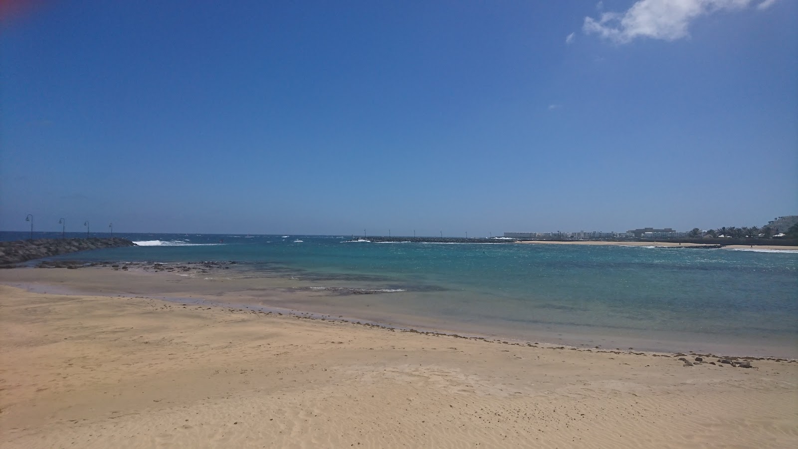 Photo de Playa de los Charcos avec sable brillant et rochers de surface