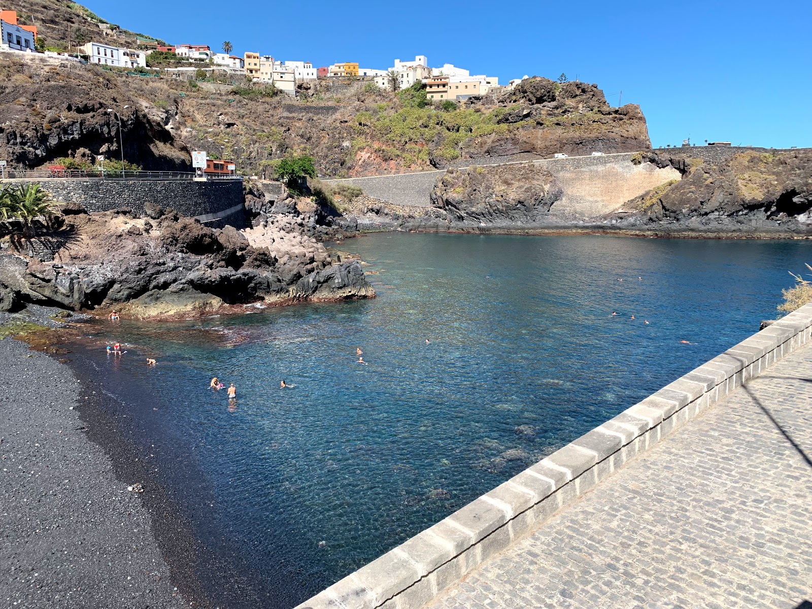 Valokuva Playa de Garachicoista. pinnalla harmaa hiekka ja kivet:n kanssa
