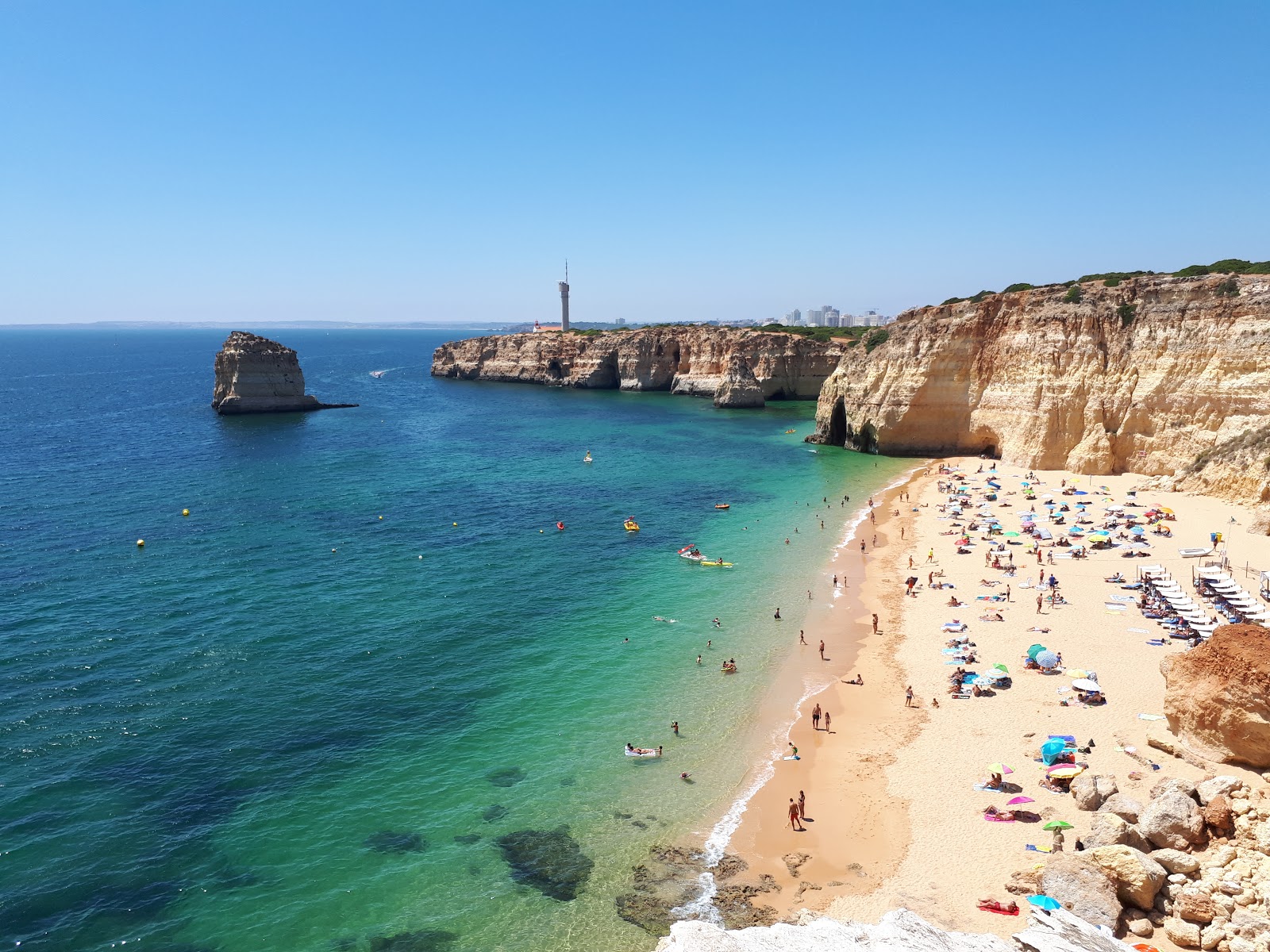 Foto av Praia dos Caneiros med fin brun sand yta