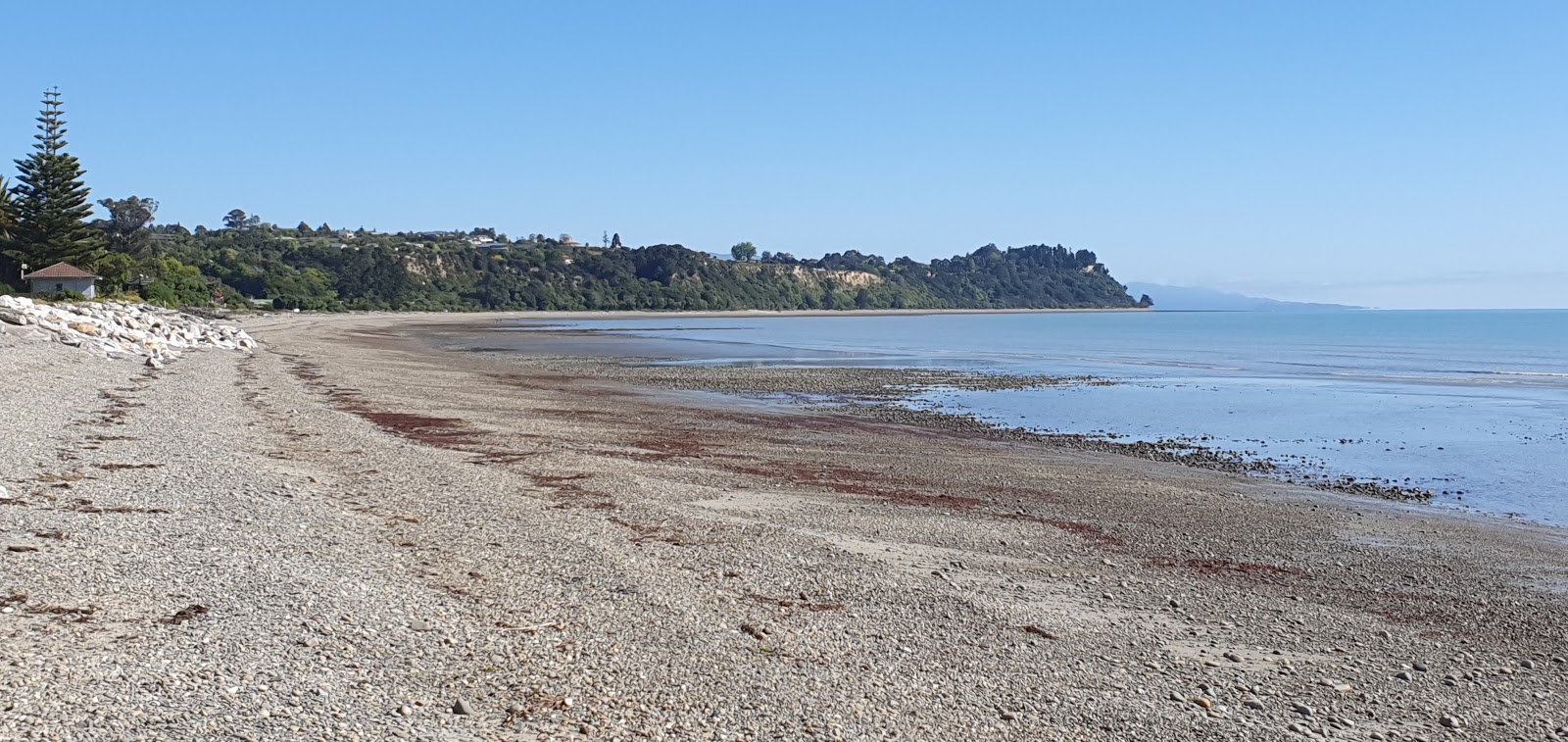 Fotografija Ruby Bay Beach II z harmaa hiekka ja kivi površino