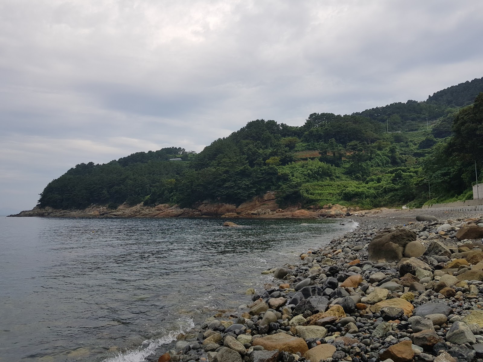 Fotografie cu Dodong Beach cu o suprafață de pietricel cenușiu