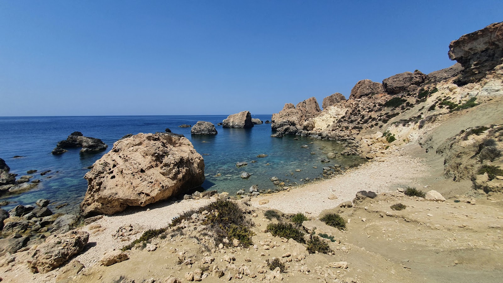 Foto di Ras Il Wahx Beach con una superficie del sabbia beige e rocce