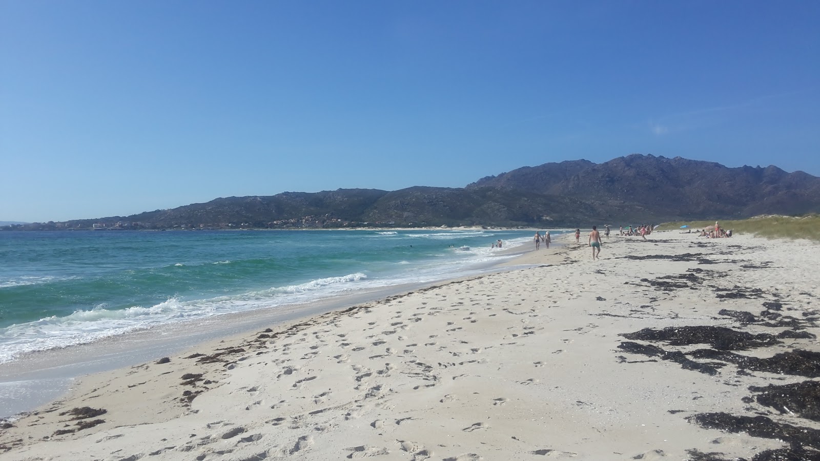 Foto de Praia de San Mamede con arena fina blanca superficie