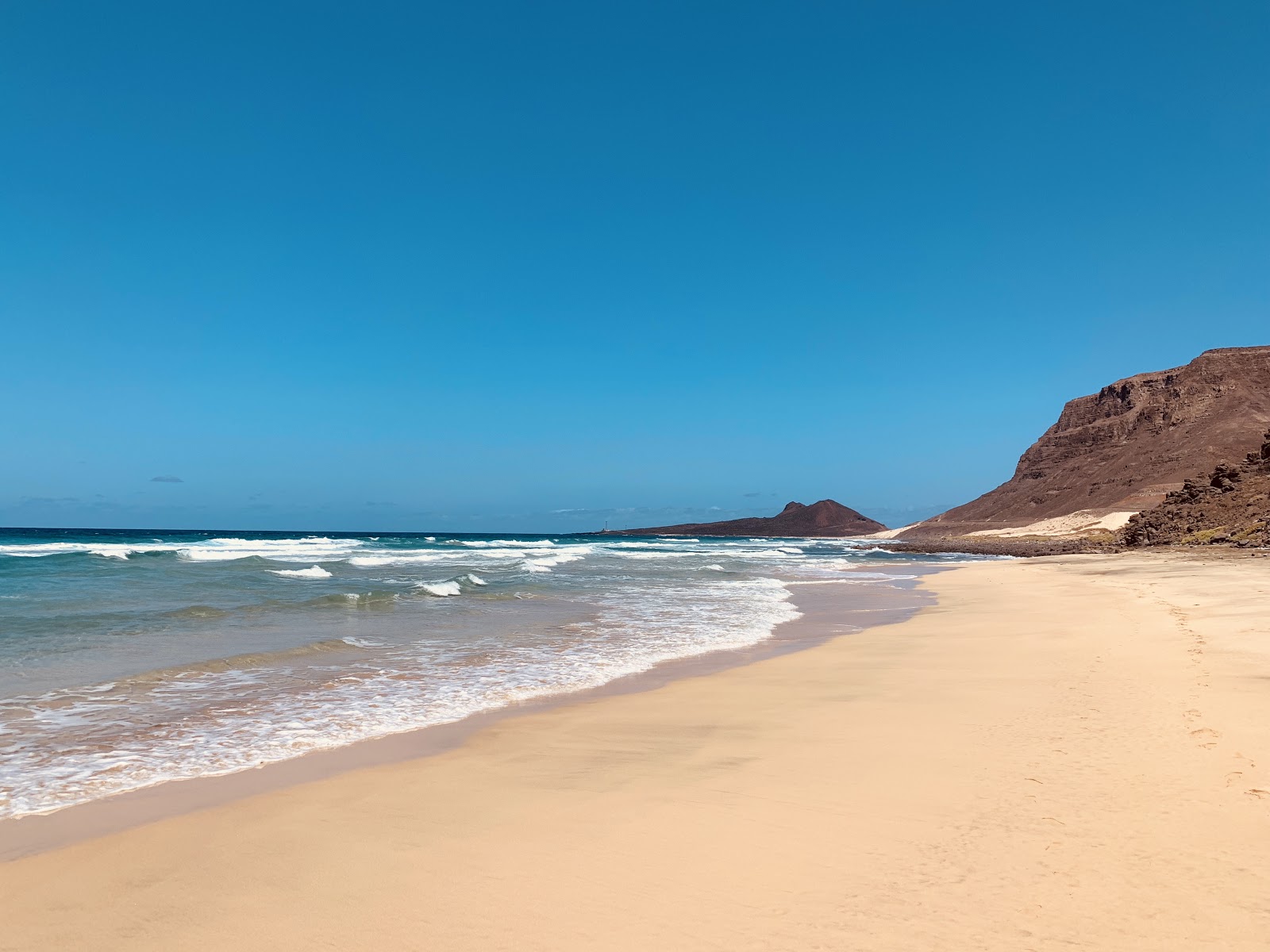 Foto van Praia Grande met helder zand & rotsen oppervlakte