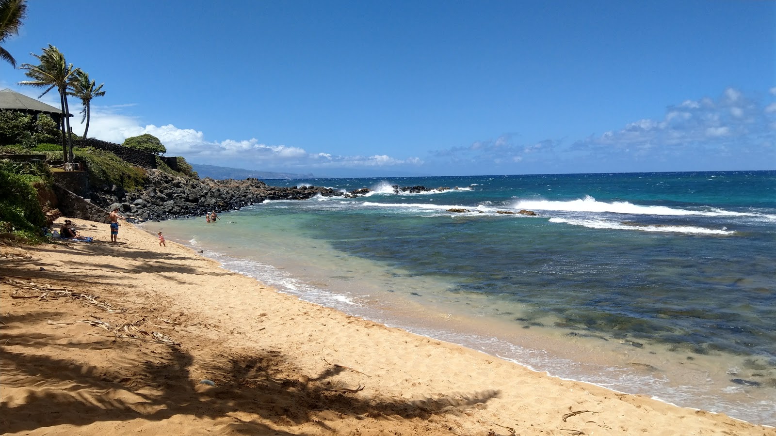 Photo of Kuau Cove Beach with bright sand & rocks surface