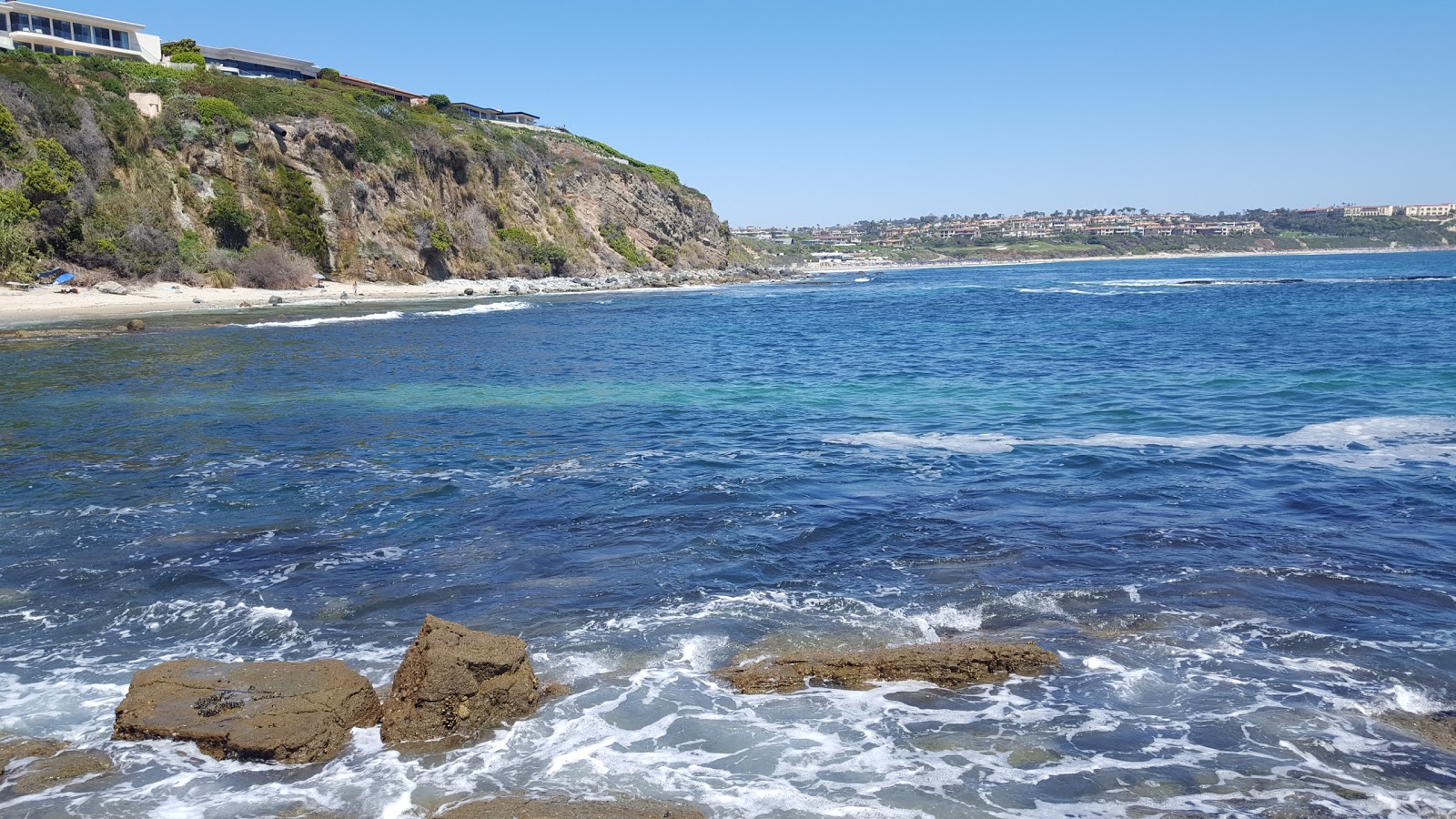 Foto von Mussel beach von Klippen umgeben