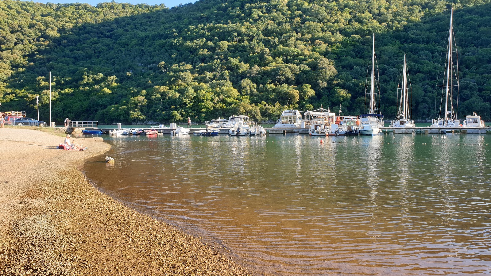 Fotografie cu Fjord beach cu o suprafață de apă verde