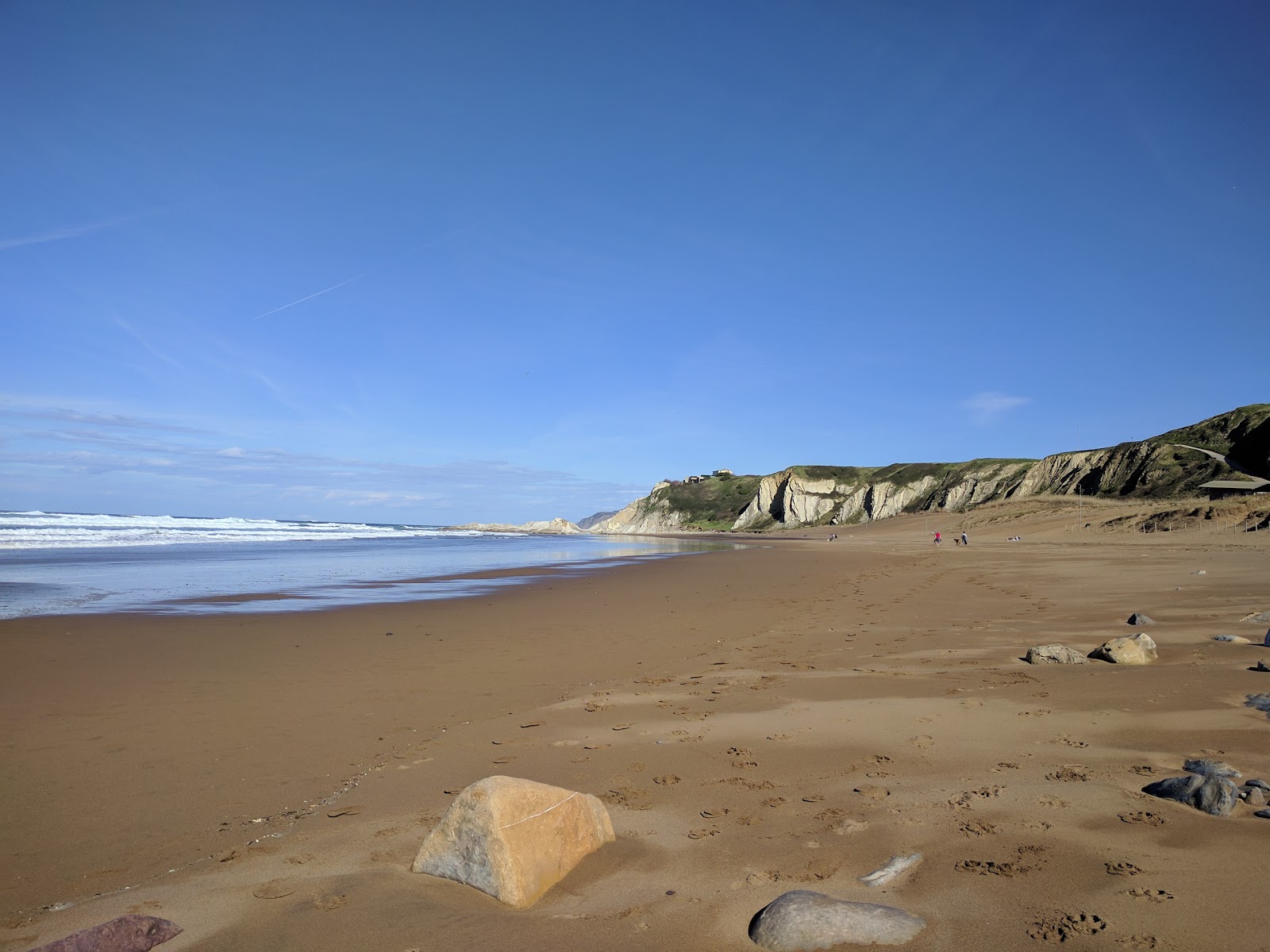 Large étendue de sable à Playa de Sopelana, avec des plages animées et des installations adaptées aux amateurs de surf.