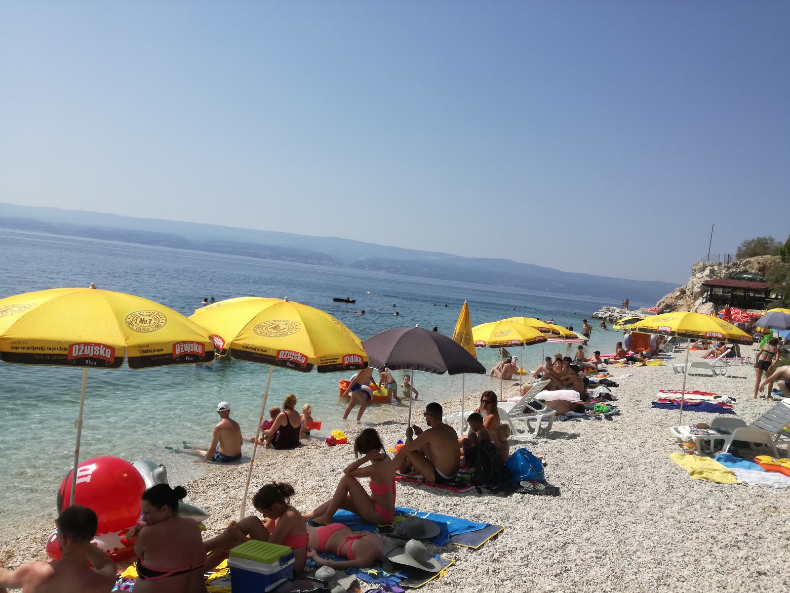 Foto af Dugi Rat Strand bakket op af klipperne