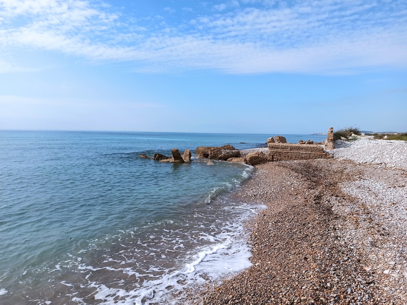Fotografija Playa de Cudola z sivi kamenček površino